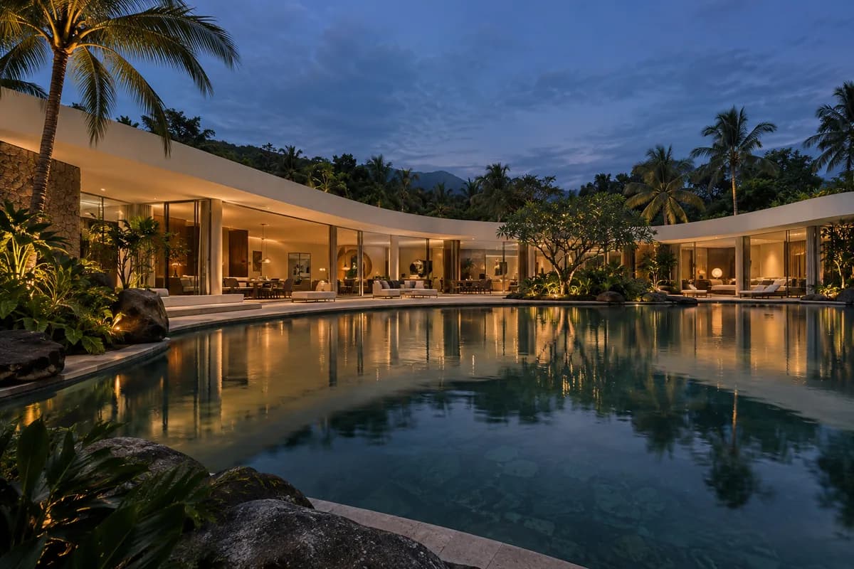 Creative reference: a long curved ivory house and reflecting pool at blue hour with a continuous roofline and balanced composition