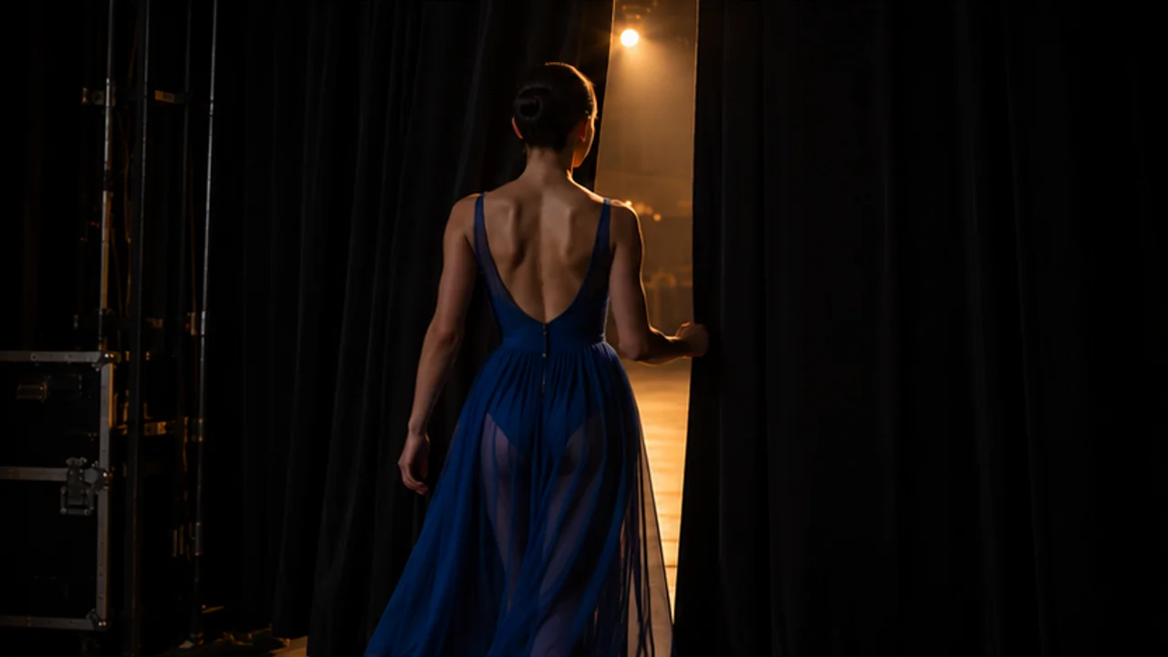 Illustrative original clip: a blue-dress dancer stands behind the theater curtains